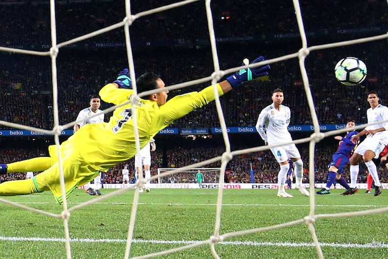 Barcelona’s Lionel Messi scores their second goal past Real Madrid’s Keylor Navas in a La Liga game on May 6 in Spain.
