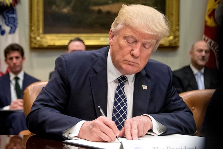 President Donald Trump signs an executive order in the Roosevelt Room of the White House in Washington in 2017.