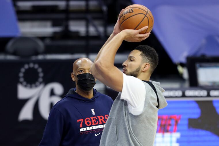 Assistant Coach Sam Cassell, left, watches the shooting motion Ben Simmons of the SIxers during pregame warm-ups at the Wells Fargo Center.