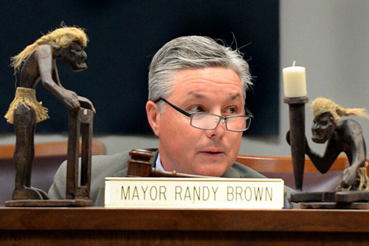 Evesham Mayor Randy Brown presides over a council meeting with his tiki figurines prominently displayed. TOM GRALISH / File Photograph