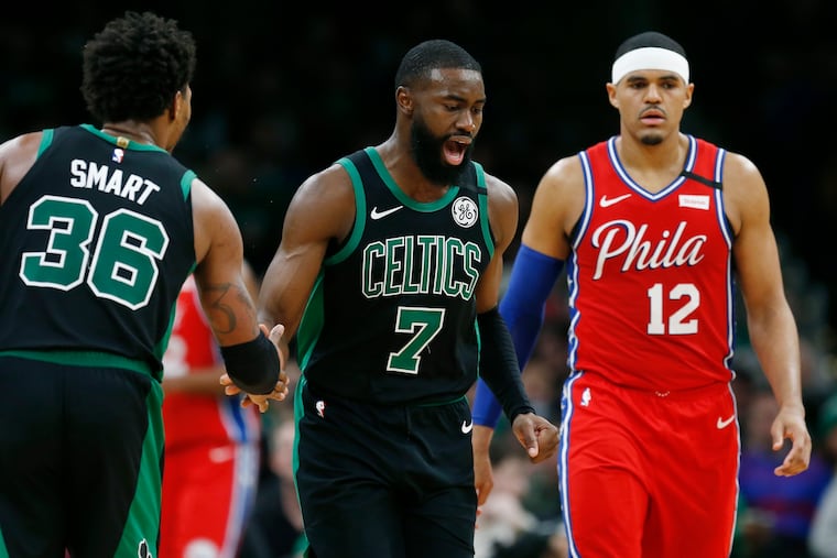 Boston Celtics' Jaylen Brown (7) celebrates with teammate Marcus Smart (36) after scoring as Sixers' Tobias Harris (12) walks upcourt during the second half of Saturday night's game at TD Garden.