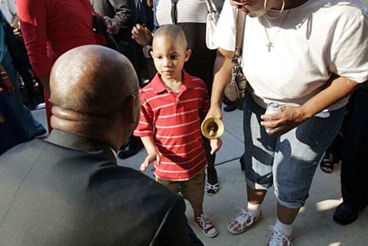 Namir Jones, 4, rings a bell with Philadelphia Mayor Michael Nutter to signal the opening day at the new Commodore Barry Elementary School.