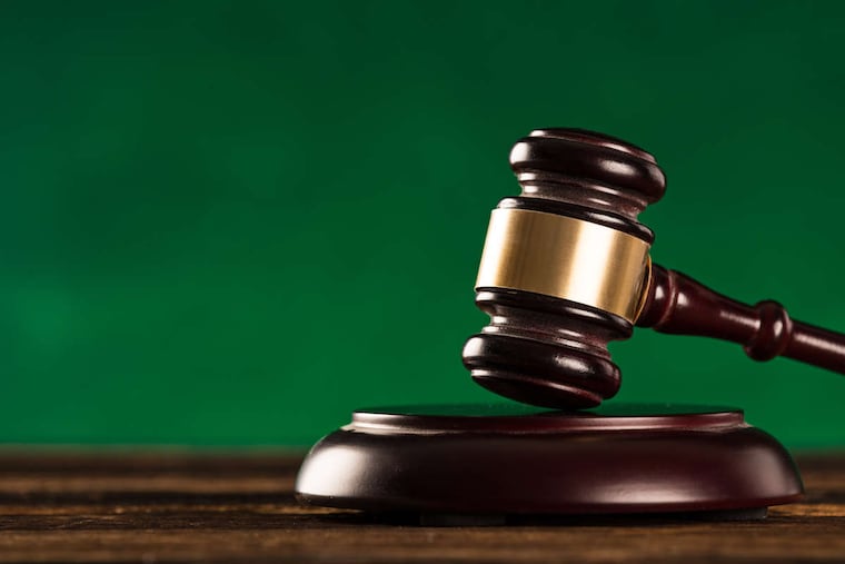 brown gavel with a brass band on wooden table.