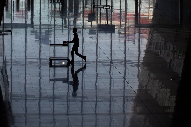 A man rolls a cart, reflected on the floor, at NATO headquarters in Brussels.