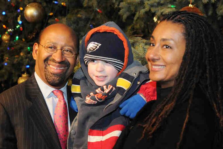 Mayor Nutter and his wife, Lisa, hold Jordan Brennan-Melo, 4, of the Northeast, for a picture next to the city tree.