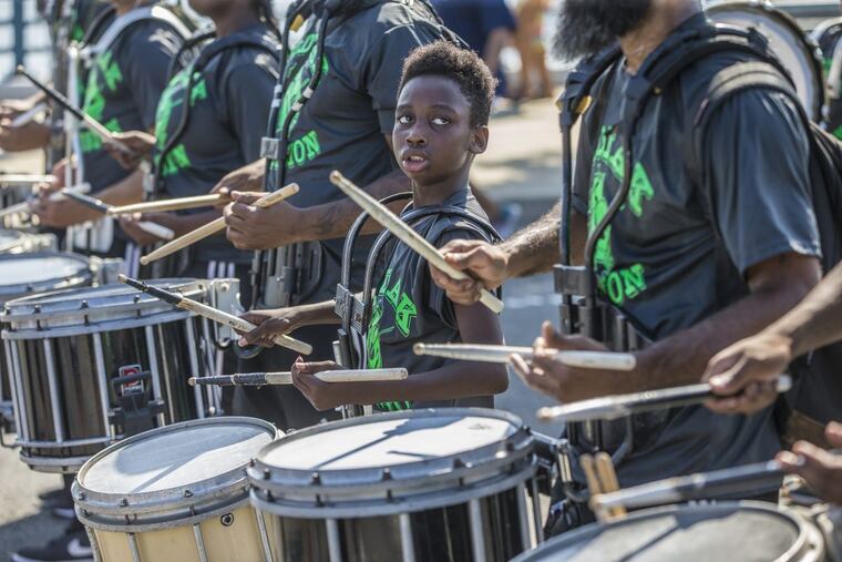 Terrell Hill, 11, of the Zodiac Percussion Drum Line, looks to one of the older drummers, as they make their way down Columbus Boulevard on September 4, 2017. A bill would have regulated drum lines in Center City.