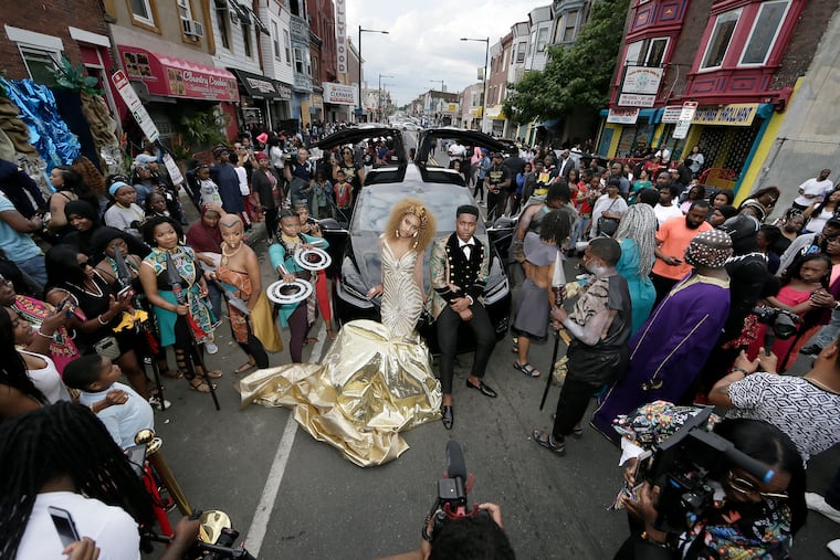 Dayanna McBride and Quian Brown pose in front of the Tesla they will take to the prom after their Wakanda-themed prom send off on 22nd St. in North Phila., Pa. on June 6, 2018.