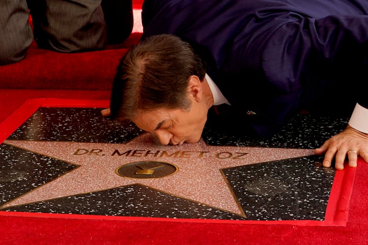 Mehmet Oz, the former host of "The Dr. Oz Show," kisses his new star on the Hollywood Walk of Fame during a ceremony Friday in Los Angeles.
