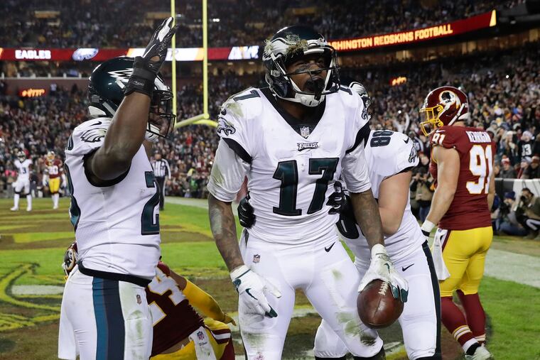 Eagles wide receiver Alshon Jeffery holds the football after scoring a touchdown with teammates running back Wendell Smallwood (left) and tight end Dallas Goedert against Washington on Sunday, December 30, 2018 in Landover, MD.