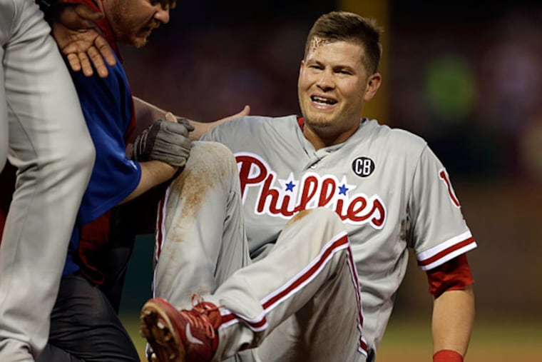 Reid Brignac is tended to by a trainer after colliding with St. Louis Cardinals starting pitcher Shelby Miller at first base during the fifth inning of a baseball game on Thursday, June 19, 2014, in St. Louis. Brignac left the game after the collision. (Jeff Roberson/AP)