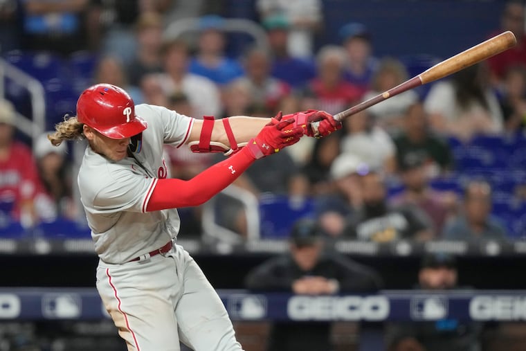 Alec Bohm follows through on a single to score Johan Rojas during the eighth inning against the Marlins.