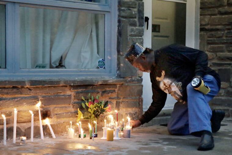 Neighbors and friends light candles at a vigil for Regina Brunner Holmes in front of her home in Mount Airy. (ELIZABETH ROBERTSON/STAFF PHOTOGRAPHER)