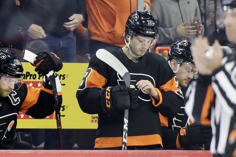 Flyers forwards Claude Giroux (left) and Ryan Hartman have dejected looks as their team faced a 2-0 second-period deficit Sunday. The New York Rangers won, 3-0.