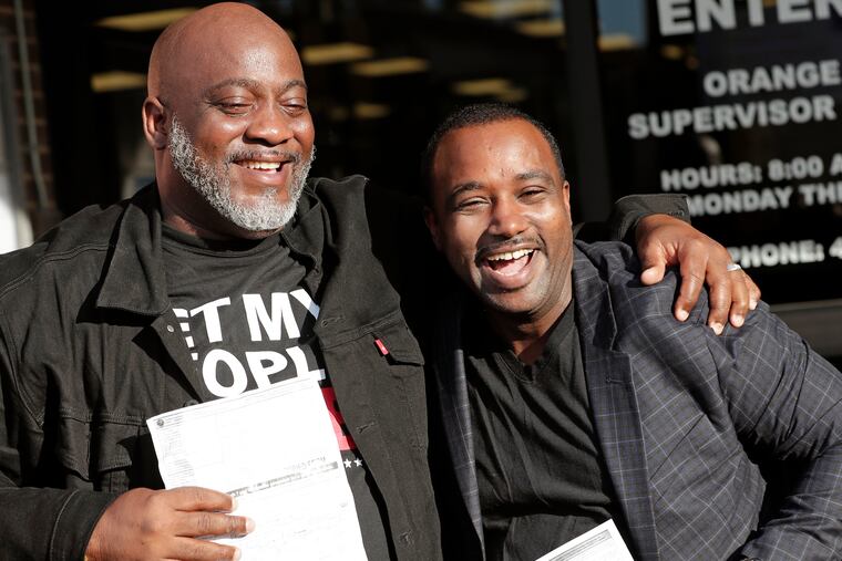 Former felons Desmond Meade, president of the Florida Rights Restoration Coalition, left, and David Ayala, husband of State Attorney Aramis Ayala, celebrate with copies of their voter registration forms after they registered at the Supervisor of Elections office Tuesday, Jan. 8, 2019, in Orlando, Fla. Former felons in Florida began registering for elections on Tuesday, when an amendment that restores their voting rights went into effect. (AP Photo/John Raoux)