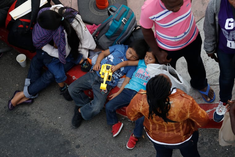 People wait to apply for asylum in the United States along the border, Tuesday, July 16, 2019, in Tijuana, Mexico. Dozens of immigrants lined up Tuesday at a major Mexico border crossing, waiting to learn how the Trump administration's plans to end most asylum protections would affect their hopes of taking refuge in the United States.