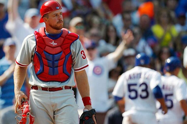 Philadelphia Phillies catcher Erik Kratz heads back to the plate after the Chicago Cubs' Welington Castillo scored during the fourth inning of a baseball game on Sunday, Sept. 1, 2013, in Chicago. (AP Photo/Andrew A. Nelles)