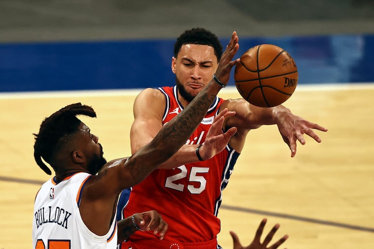 The 76ers' Ben Simmons, right, passes under pressure from the New York Knicks' Reggie Bullock.