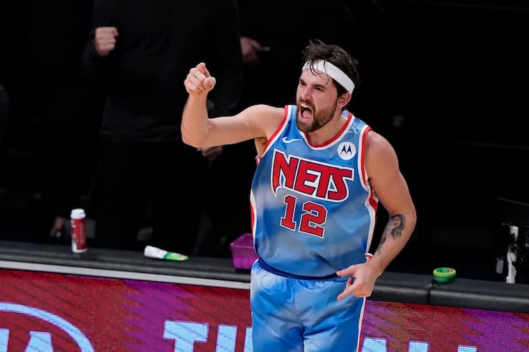 The Nets' Joe Harris reacts after making a three-point basket during the first half against the Sixers.