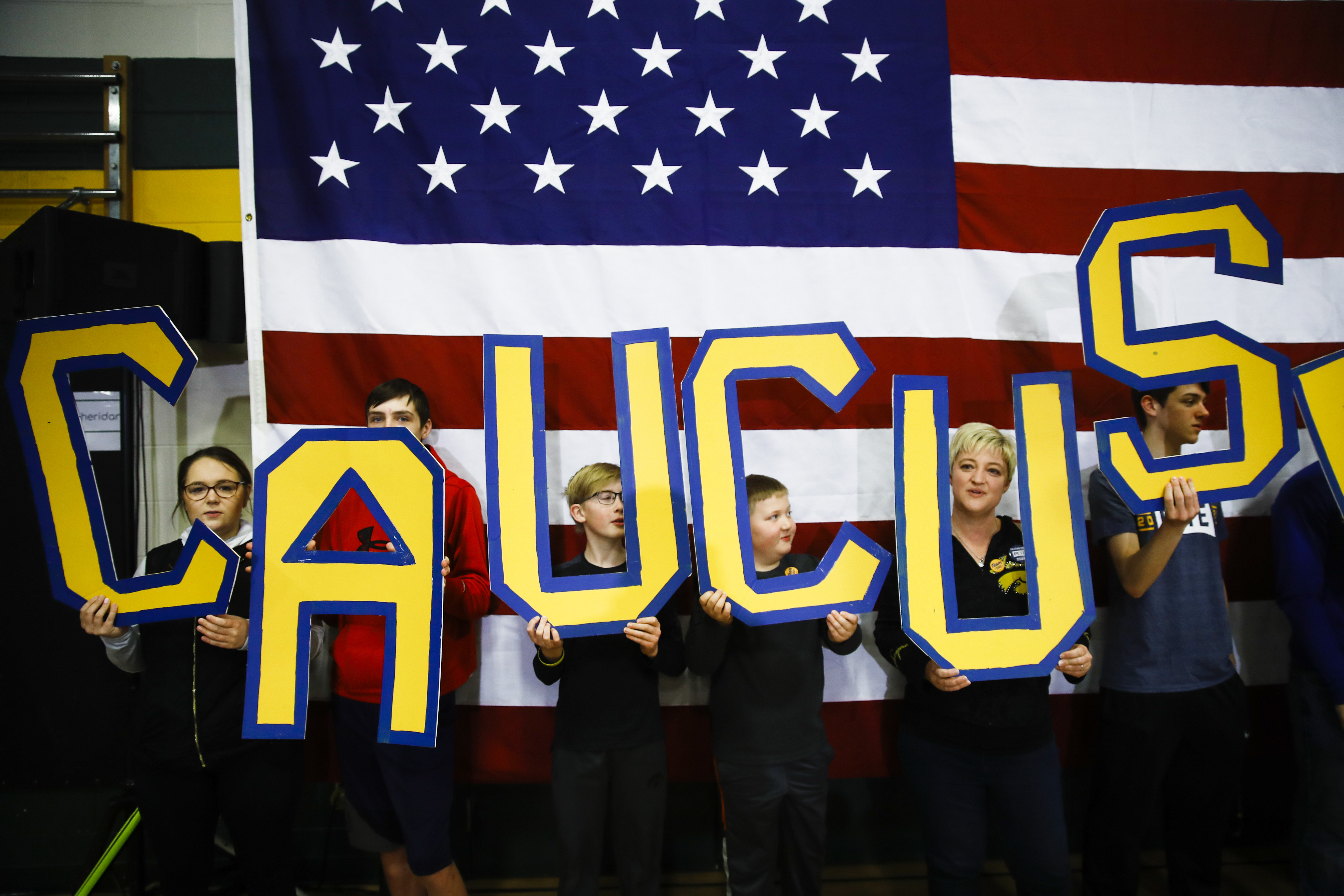 FILE - In this Sunday, Feb. 2, 2020, file photo, attendees hold letters that read "CAUCUS" during a campaign event for Democratic presidential candidate former South Bend, Ind., Mayor Pete Buttigieg at Northwest Junior High, in Coralville, Iowa. Sorting through the wreckage isn't just a humbling experience for the state's Democrats _ it's also a cautionary tale. The disaster has already reshaped how Nevada will run its caucuses 11 days from now and raised questions about whether caucuses, often criticized as quaint vestiges of another political time, can survive in the modern era. (AP Photo/Matt Rourke, File)