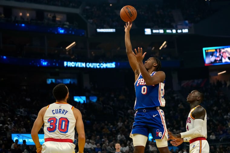 Sixers guard Tyrese Maxey shoots between Golden State Warriors guards Stephen Curry (30) and Dennis Schröder on Jan. 2 in San Francisco.