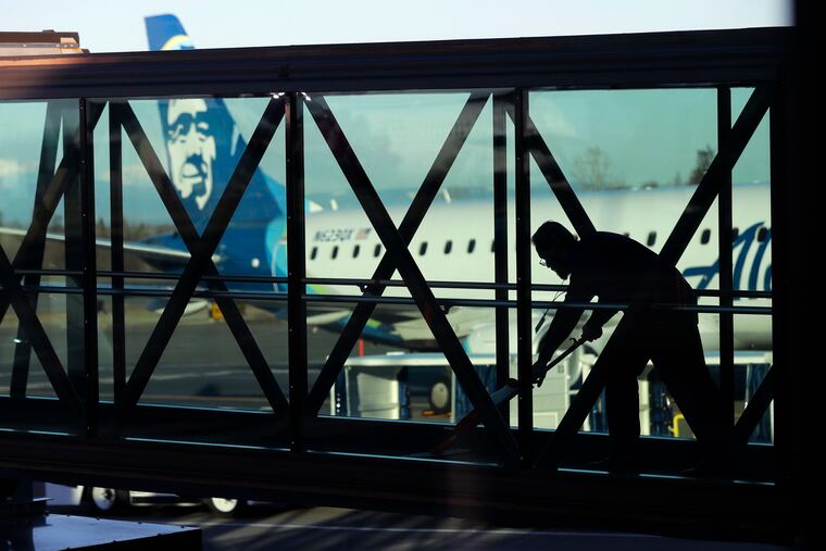 A worker cleans a jet bridge before passengers board an Alaska Airlines flight to Portland, Ore., at Paine Field in Everett, Wash., in March. U.S. employers added 263,000 jobs in April.