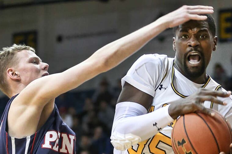 La Salle's Rohan Brown grabs a rebound while hounded by Penn's Sam Jones at Tom Gola Arena. The Explorers dominated on the boards.