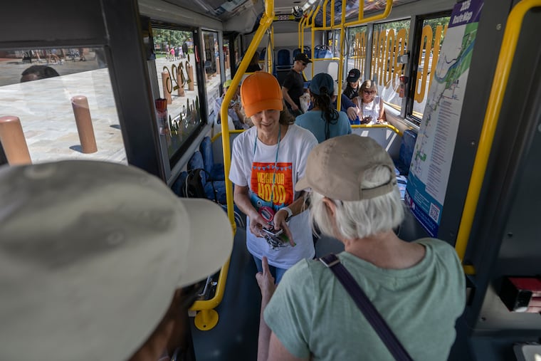 Tour guide Marianne Ruane welcomes passengers aboard the PHLASH bus at the start of the "Neighborhood Jawnts" tour in Philadelphia on July 24.