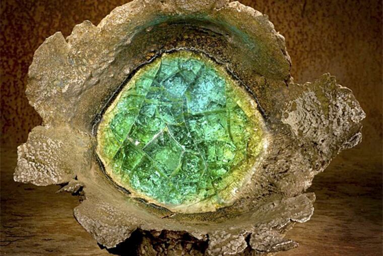 "Exploded Clay/Bang Pot" by Steve Tobin, made by embedding fireworks in blocks of clay, detonating them, and then firing them with shards of glass. A video of the process, with the artist explaining as he goes, provides a context otherwise missing in the show.