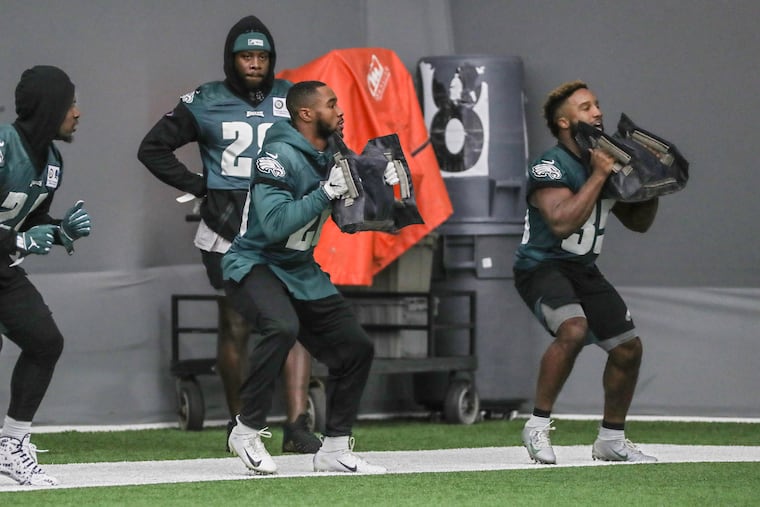 Eagles running backs (from left) Jordan Howard, Miles Sanders and Boston Scott participating in a drill last week, in front of the since-released Jay Ajayi.