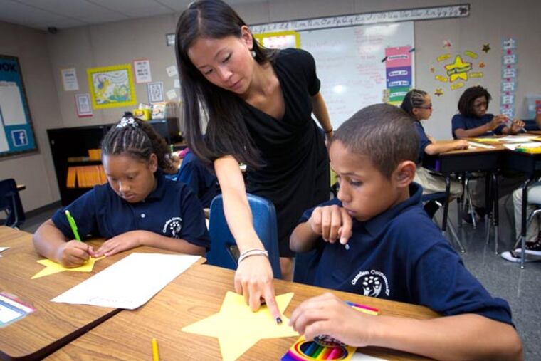 Nicole DeVicci, 5th-grade teacher works with students on bulletin board decorations. Wednesday was the first day of school at the newly opened Camden Community Charter School at 8th St. and Linden in Camden, NJ ( ALEJANDRO A. ALVAREZ / STAFF PHOTOGRAPHER )