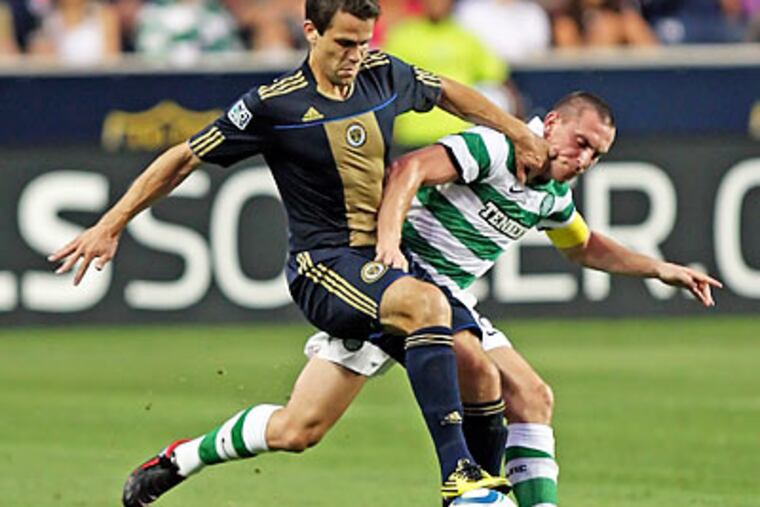Stefani Miglioranzi battles Celtic's Scott Brown for the ball during the first half. (Steven M. Falk/Staff Photographer)