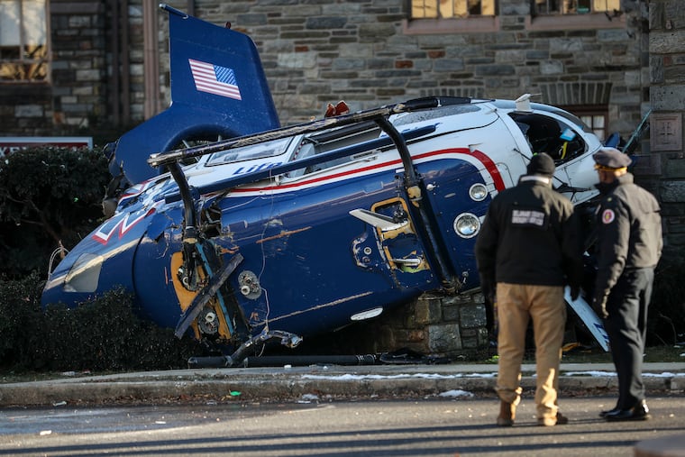 Officials take a look at the scene of a helicopter crash at Burmont Road and Bloomfield Avenue in Drexel Hill on Tuesday. A medical helicopter carrying an infant crashed in the residential neighborhood, leaving the four passengers with non-life threatening injuries, according to local authorities.