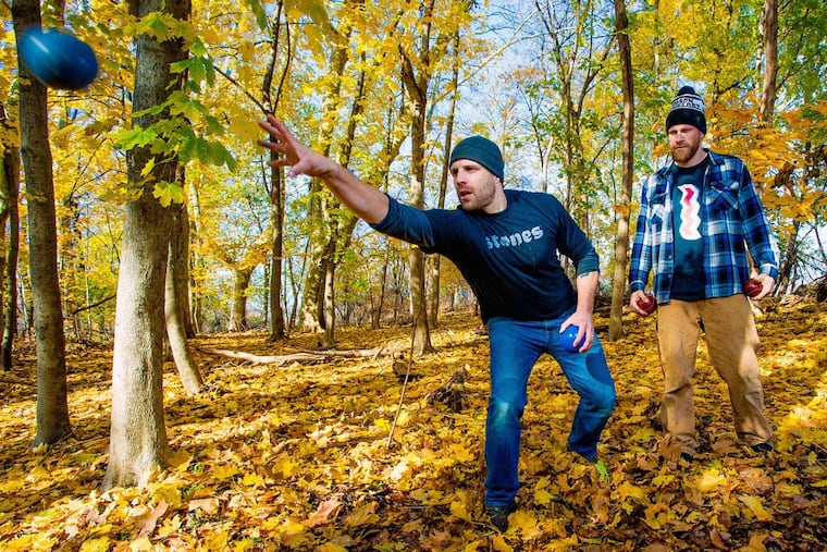 Chris Kinka (L) and John Janick demonstrate throwing a 'stone' at their soon-to-be completed Philly Stones course in Fairmount Park in Philadelphia. The Commission on Parks and Recreation awarded them the use of the land for the next 4 years in a contest for innovative ideas to improve Philadelphia’s parks and recreation system.