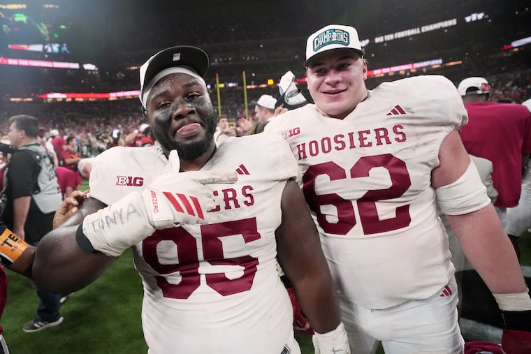 Indiana's Tyrique Tucker (95) and Drew Evans celebrate after beating Ohio State for the Big Ten championship.