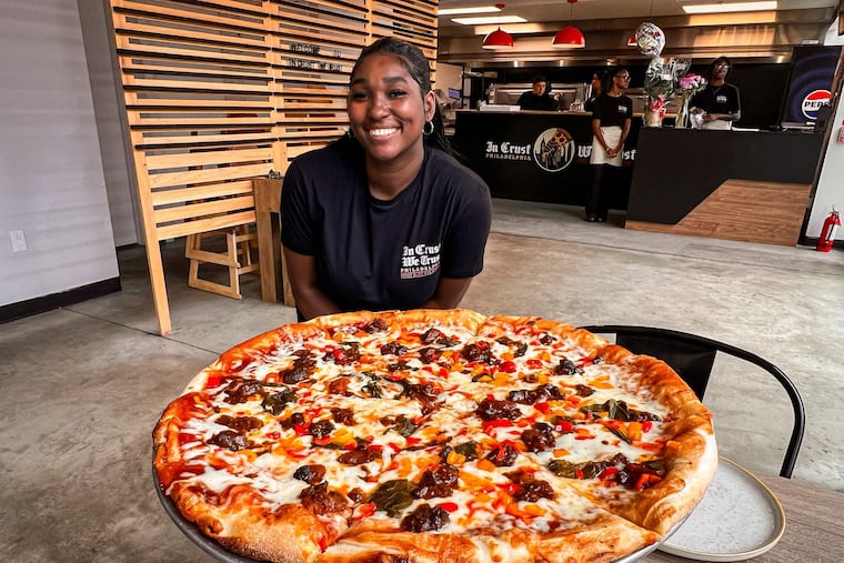 Anyae Wilson-Worley with the Uptown Crown pizza, topped with oxtail, at In Crust We Trust.
