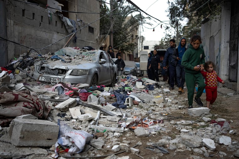 Palestinians look at the destruction after an Israeli airstrike in Rafah on Friday.