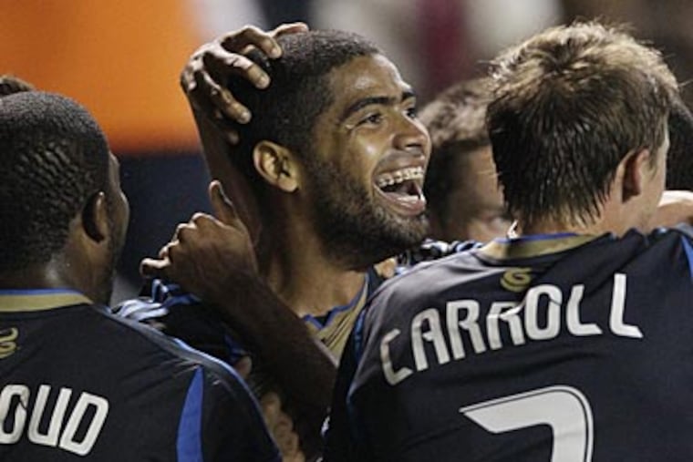 Union midfielder Gabriel Gomez, center, smiles after scoring a goal against the Fire on Wednesday. (Nam Y. Huh/AP)