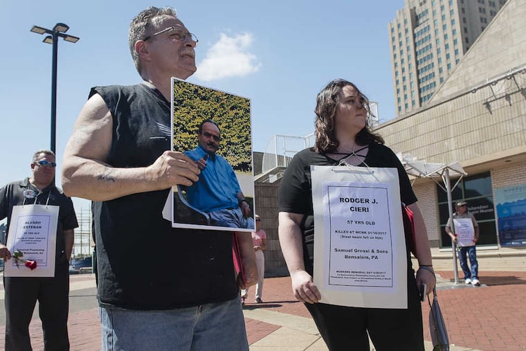 Thomas Ciera, left, holds a photograph of his brother Rodger Ciera, who died on the job Jan. 16 at age 57. Rodger Ciera, who had a wife, five children and eight grandchildren, was killed when a steel beam fell on him at Samuel Grossi and Sons, a steel fabrication company in Bensalem. Brianna Ciera, right, Rodger Ciera’s daughter, tossed a rose into the Delaware River in honor of her father at the annual Worker’s Memorial Day ceremony at Penn’s Landing. This year’s ceremony especially honored 134 people from the tri-state area who were killed at work.