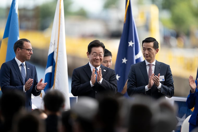 South Korean President Lee Jae Myung (center) gestures as he arrives at the Hanwha Philly Shipyard for a ship christening ceremony on Tuesday, August 26, 2025, in Philadelphia, joined by Kim Dong-Kwan (DK), the Hanwha group's vice chairman, and Pennsylvania Gov. Josh Shapiro. Hanwha has agreed to lead $5 billion in Korean investments in the yard amid trade, tariff and military procurement talks with President Trump. Hanwha, which has much larger shipyards in Korea, says it hopes to hire at least 3,000 more Philadelphians, add robots, new buildings, piers, cranes, and dry-docks, and boost Philly ship production from the current one every 8 months to 20 a year.