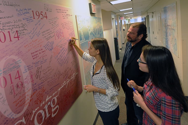 Julia Pankova (left), 24, a television reporter from Kiev, and Maria Usenko (right), 21, an online journalist from Kiev, sign the "visitor signing board," with Phil Beck of the Philadelphia chapter of the Society of Professional Journalists at Citizen Diplomacy International. Citizen Diplomacy International is celebrating its 60th anniversary this year. ( CLEM MURRAY / Staff Photographer )
