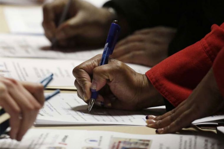 A too-familiar scene still: Applicants filling out forms at a jobs fair in Newark, N.J. (Mark Lenninhan / Associated Press)
