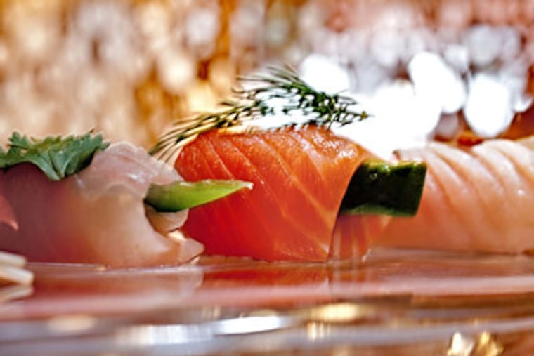A chef's choice sashimi appetizer includes seared albacore with fried garlic chips and chive (right), salmon with avocado and dill, and hamachi with shiso leaf. (DAVID M WARREN / Staff Photographer)