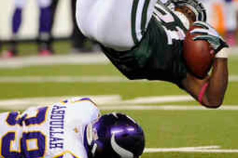 New York's LaDainian Tomlinson is upended by Minnesota's Husain Abdullah, above. Below, new Viking Randy Moss turns upfield. The game ended too late for this edition.