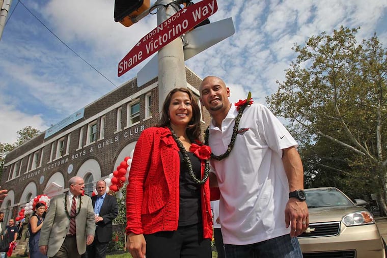 Shane and Melissa Victorino stand below a newly installed street sign that reads Shane Victorino Way outside the Nicetown Boys and Girls Club on Sept. 22, 2011.