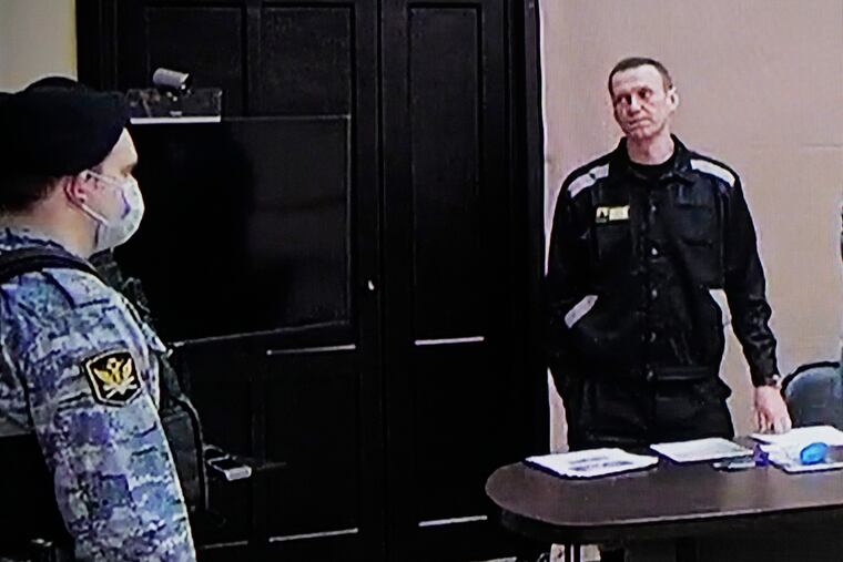 Russian opposition leader Alexei Navalny (right), is seen via a video link provided by the Russian Federal Penitentiary Service, standing during a court session in Pokrov, Vladimir region, about 60 miles east of Moscow, on Tuesday.