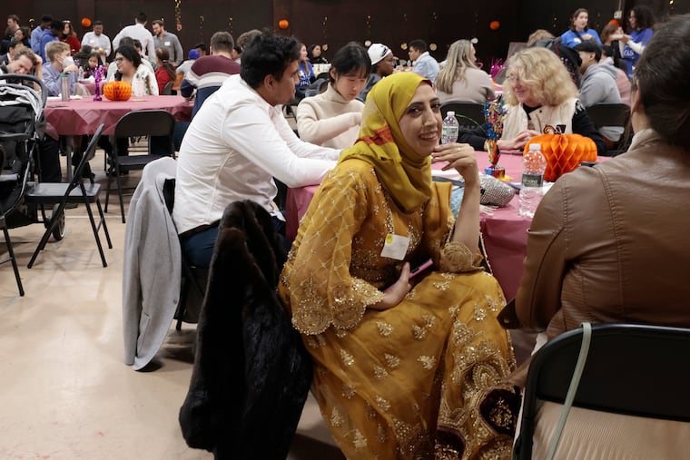 Frozen Anwari (center) and volunteer Frances Fisher (right back to camera) visit during the HIAS Thankful Together Thanksgiving dinner that was served by volunteers at the Old Pine Community Center on Lombard St. in Philadelphia on Sunday, Nov. 19, 2023. Thankful Together brings together HIAS Pennsylvania’s immigrant and refugee clients to celebrate Thanksgiving and learn about this uniquely American holiday. For many clients, it will be their first Thanksgiving since arriving in the United States.