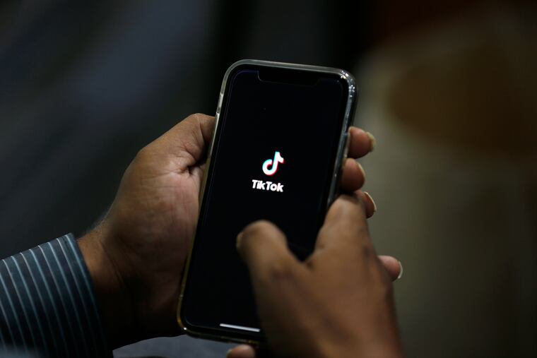 A man opens the social media app TikTok on his cell phone.