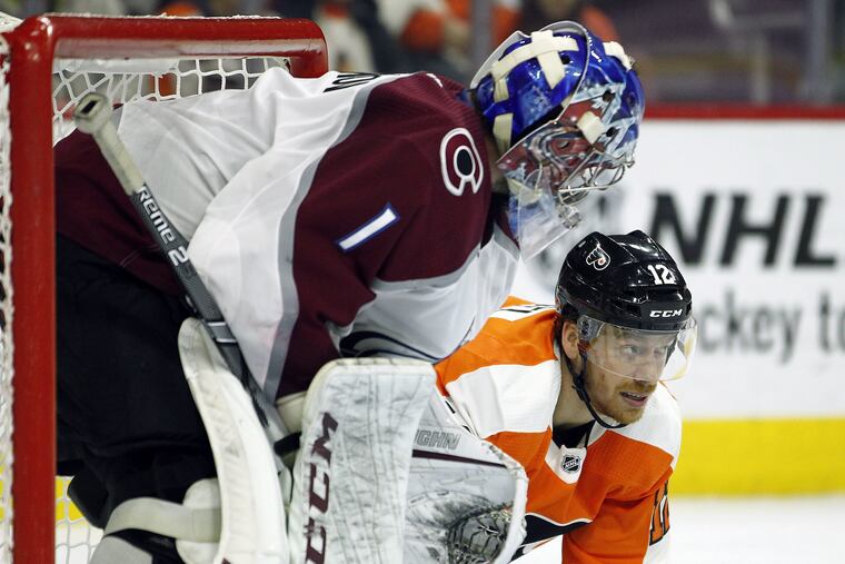 Colorado Avalanche goalie Semyon Varlamov looks at Flyers left winger Michael Raffl who struggles to get up after being checked into the boards by the Avalanches' Avalanche's Patrik Nemeth on Monday. Raffl will be sidelined four to six weeks with a suspected left-foot injury.
