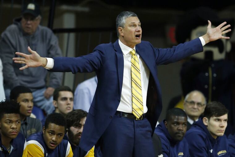 La Salle Head Coach John Giannini raises his arms towards his team.