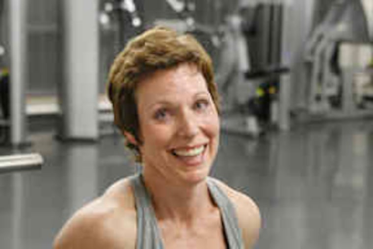 Leslie Spencer, a professor of health and exercise science at Rowan University, catches her breath while working out. She wears compression sleeves to control lymphedema swelling.